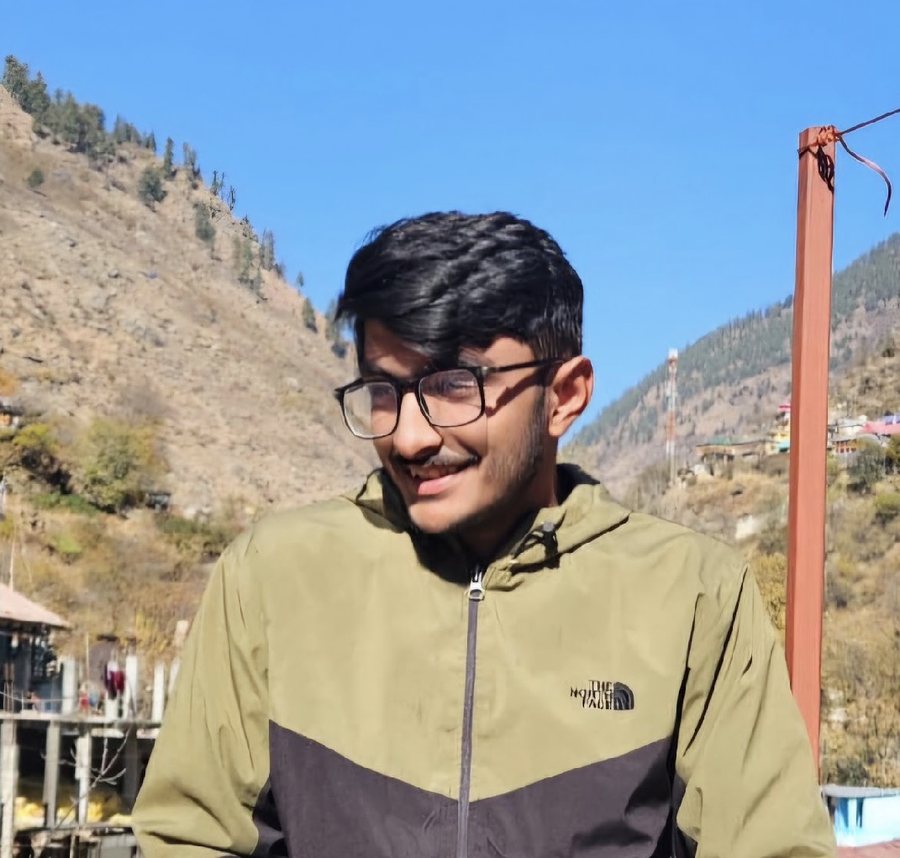 Sujal Negi smiling, mountains of Himachal behind him